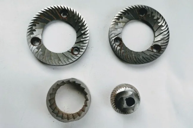 on the top a set of italian flat burrs on the bottom a set of conical steel burrs