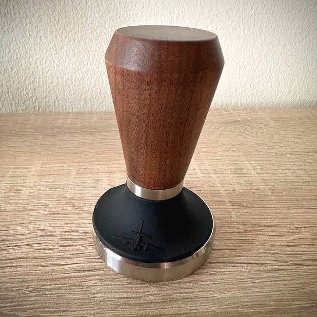 Mhw-3bomber tamper with walnut handle on wooden table and white background