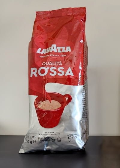 lavazza qualita rossa on black table with a white wall backgroun